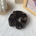 Soft dark brown velvet hair scrunchie shown on a minimalist white textured background - Coffee