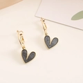 Detail of heart drop earrings with gold frames and grey marble resin on a beige background - Black