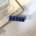 Dettaglio di cinque orsetti in resina blu traslucida con paillettes su fermagli dorati - Blu scuro