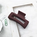 Detail of a matte deep red square hair claw clip on a minimalist white cotton background - Burgundy