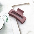 Detail of large matte dusty rose hair claw clip for elegant styling on fabric background - Deep Pink