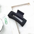 Detail shot of a large matte black square hair claw clip on a minimalist background - Black