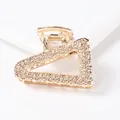 Macro shot of a golden triangle claw clip with sparkling glitter texture detail - Triangle - Gold