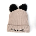 Close-up of beige knit hat featuring plush black cat ears and embroidered whiskers detail - Beige