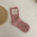 Pink ribbed wool blend mid-calf sock with a minimalist stitched logo label on a white background - Peach Pink