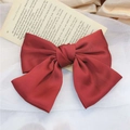 Elegant wine red satin oversized bow hair clip on a soft white fabric background - Spring Clips / Red