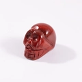 Polished red jasper carved skull figurine with natural stone texture and gloss finish - Rainbow