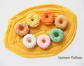 Set of seven colorful squishy donut charms with frosting on a yellow fluid background - Lemon Yellow