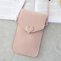 Pink crossbody phone bag with gold heart clasp and fine stitching on stone background - Light Pink