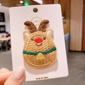 Macro view of handmade knit reindeer hair clip with festive red nose and green collar - Reindeer
