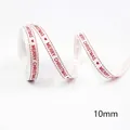 Detail of 10mm white Christmas ribbon with red Merry Christmas text and hearts - White Red Merry Christmas-5 Yards