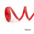 Detail shot of 10mm red Christmas ribbon featuring white star patterns on textured fabric - Red White Stars-100 Yards