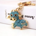 Cute golden cow keychain with blue sparkling crystals on a book edge backdrop - Single Piece / Blue