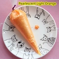 Dettaglio di colla crema arancio chiaro perlato in sac à poche con motivo a stella sul piatto - 100g (Premere lentamente per una migliore consistenza) / Arancione Chiaro Perlescente