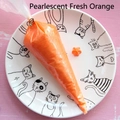 Close-up of pearlescent orange cream glue for DIY crafts in a white cat-themed plate - 100 g / Pearlescent Bright Orange