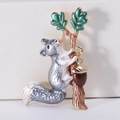 Detailed macro view of squirrel brooch with enamel leaves and dangling golden nut charm - Gray