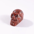 Polished natural stone skull carving in red and black mottled texture for Halloween decor - Red Sesame Stone