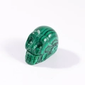 Green malachite crystal skull carving with natural dark stripes and polished finish - Malachite
