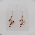 Detailed view of candy cane earrings with red white stripes and golden bows - Christmas Candy Cane