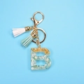 Letter B resin keychain with gold leaf, stones and fringe tassel on blue backdrop - Letter B