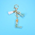 Detail of resin letter L keychain with gold foil, teal stones and soft tassels - L