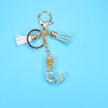 Detail view of resin letter J keychain with gold foil, green stones and tassel - Letter J