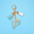 Resin letter P keychain with green stones, gold foil, and stylish tassels on blue back - Letter P
