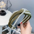 Detail eines dunkelgrünen Stoff-Haarreifens mit eleganten weißen Perlenreihen und Knoten - Olivgrün