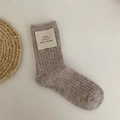 Beige knitted wool socks with rib pattern and small label on clean white background - Pink Taro Red