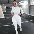 Dettaglio di un completo sportivo bianco a due pezzi con top corto a maniche lunghe e pantaloni - Taglia S / Top E Pantaloni / Bianco
