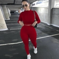 Dettaglio del set sportivo rosso a due pezzi con pantaloni a vita alta e maglia attillata - Taglia S / Top E Pantaloni / Rosso