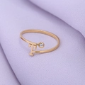 Detail van een minimalistische gouden ring met T-vorm en een enkele glanzende steen - Goud-T