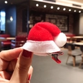 Mini fermaglio per capelli a cappello di Babbo Natale rosso e bianco in mano - Cappello Morbido