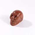 Carved gold sandstone skull ornament with shimmering metallic finish on white background - Gold Sandstone
