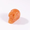 Carved natural orange crystal skull figurine ornament for home decor on white background - Topaz