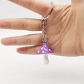 Close-up of purple mushroom keychain with white polka dots and silver metal ring - Purple