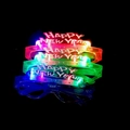 Dettaglio di quattro occhiali LED luminosi Happy New Year in vivaci colori neon su nero - Occhiali Felice Anno Nuovo a 4 LED