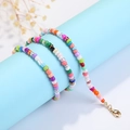 Cadena para gafas de cuentas coloridas con cierre dorado en soporte de exhibición azul - Mostacillas