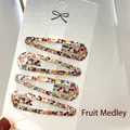 Set of four 6cm hair clips featuring colorful fruit prints on a white display card - Fruit Medley