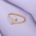 Detail van de gouden ring met letter Y en een zirkonia steen op een zachte stof - Goud-Y