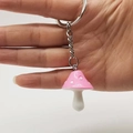 Dettaglio di un portachiavi a fungo in resina rosa con pois bianchi e anello in metallo - Rosa