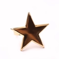 Star-shaped golden metal napkin ring with pearl snowflake design on white background - Pentagram