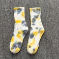 Baumwoll-Batiksocken in Gelb und Grau mit Fleckmuster auf einem grauen Teppichboden - Einheitsgröße / Gelb-Grau Batik