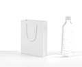 Sacchetto regalo in cartone bianco con manici intrecciati accanto a una bottiglia per scala - Verticale 16*22*8cm