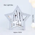 Scatola luminosa a stella in legno con cervi intagliati su morbido peluche bianco - Forma di stella