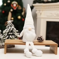 Nordic Christmas gnome plush doll with long legs sitting on a wooden stool in a cozy home - Long Leg Style / Off White