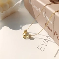 Dettaglio ravvicinato di un ciondolo a fibbia a U dorato con cristalli pavé brillanti - Oro