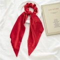 Elegant red velvet scrunchie with long streamers on a white decorative plate - Red Velvet Streamer