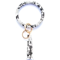 Detail of snake skin print leather keyring bracelet with golden ring and long fringe tassel - Black White Snake Pattern