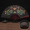 Classic 10-inch folding fan with double dragon pattern and golden calligraphy details - 10 Inch Black Two Dragons Playing with a Pearl